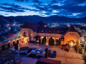 a large building with cars parked in a parking lot at Hotel-Restaurant La Belle Epoque in Petroşani