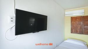 a flat screen tv hanging on a wall at Suite em Guriri Norte com Piscina e Academia in São Mateus
