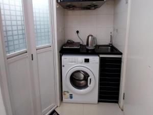 a small kitchen with a washing machine and a sink at bnb's in Hong Kong +4 photos