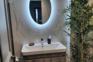 a bathroom with a white sink and a mirror at Sea views-Balcony-Sleeps 6-Parking-AirCon Heating in Daimuz