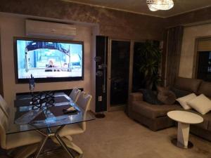 a living room with a table and a tv on the wall at Sea views-Balcony-Sleeps 6-Parking-AirCon Heating in Daimuz