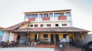 a building with a motorcycle parked in front of it at Suite em Guriri Norte com Piscina e Academia in São Mateus