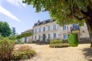 a green suitcase hanging from a tree in front of a building at La Montagne in Tournus