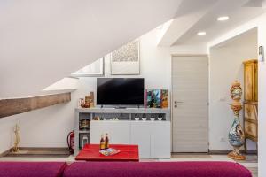 a living room with a tv and a red rug at Mansarda in pieno centro in Savona