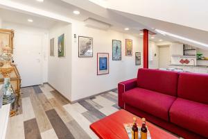 a living room with a red couch and a table at Mansarda in pieno centro in Savona