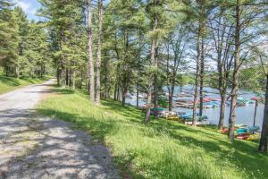 a road next to a lake with trees at Woodlore by Railey Vacations in Swanton