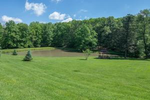 a green field with a pond and a gazebo at Woodlore by Railey Vacations in Swanton
