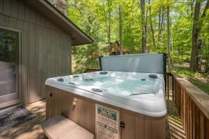 a hot tub on the deck of a house at Woodlore by Railey Vacations in Swanton +34 photos