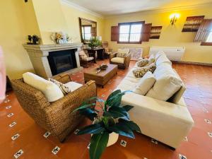 a living room with white couches and a fireplace at Dehesa La Parrilla - VUT- Eventos in Pepino
