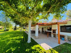 a tree in a yard next to a building at Dehesa La Parrilla - VUT- Eventos in Pepino