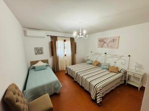 a bedroom with two beds and a chandelier at Dehesa La Parrilla - VUT- Eventos in Pepino +67 photos