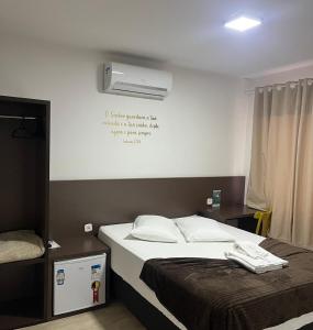 ein Schlafzimmer mit einem Bett und einer Klimaanlage an der Wand in der Unterkunft Hotel Blumenpark in Rio Negro + 10 Fotos