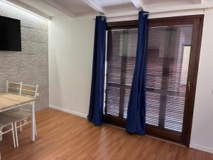 a dining room with blue curtains and a table at Casa Nietta in Olbia
