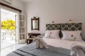 ein Schlafzimmer mit einem großen weißen Bett und einem Fenster in der Unterkunft Villa Kalamia Dolphin in Perissa + 23 Fotos