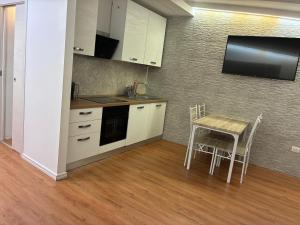 a small kitchen with a table and a tv on the wall at Casa Nietta in Olbia