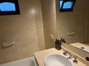 a bathroom with a sink and a tub and a mirror at Casa balcarce in Salta +13 photos