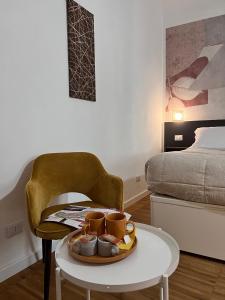 a tray of cups on a table in a bedroom at DIMOR'A' ROOMS in Tuscany in Pitigliano
