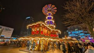 a group of people standing around a carousel at a carnival at Park Inn by Radisson Berlin Alexanderplatz in Berlin