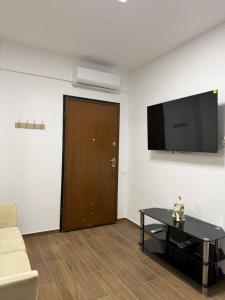 a living room with a couch and a television on a wall at Le Grace, Urban Retreat near Near CityCenter & Sea in Thessaloniki +17 photos