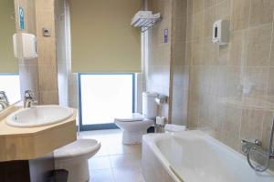 a bathroom with a tub and a toilet and a sink at Hotel Cardeña by gaiarooms in Burgos