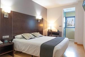 a bedroom with a large bed with two pillows at Hotel Cardeña by gaiarooms in Burgos