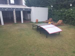 a ping pong table and two chairs in a yard at Elu in Ingeniero Giagnoni
