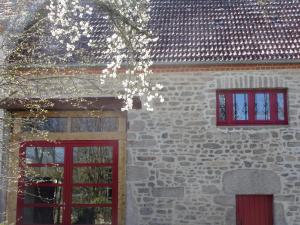 a brick building with two windows and a red door at Gîte Charlange in Pradelette +11 photos