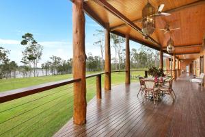 a porch with a table and chairs on a deck at Lake Tinaroo Waterfrontage in Barrine