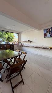 a dining room with a table and chairs and a counter at Pousada Manancial in Itaúnas