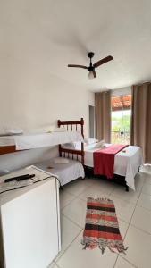 a bedroom with two beds and a ceiling fan at Pousada Manancial in Itaúnas +71 photos