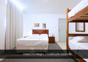a bedroom with two beds and a bunk bed at Hotel Oro Negro in Talara