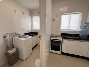 a white kitchen with a sink and a stove at Baía dos Golfinhos in Bombinhas +284 photos
