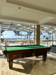 a pool table in a room with a view of the ocean at Borg El Arab Beach Resort in Dawwār ‘Abd al Qādir Qāsim