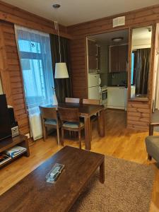 a living room with a table and a kitchen at Chalet Ylläs C413 included bed linen and towels in Ylläs +9 photos