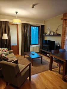 a living room with a couch and a table at Chalet Ylläs C413 included bed linen and towels in Ylläs