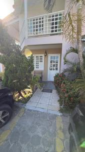 a white house with a white door and a porch at Casa maricota in Porto Seguro