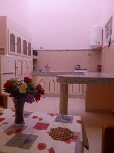a kitchen with a counter and a vase of flowers at Maison de vacances zuine in Oujda +6 photos
