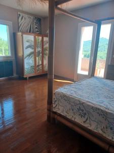 a bedroom with a bed in a room with windows at Maison Sol Air in Montazels