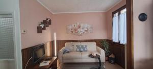 a living room with a couch and a television at La casetta di Marilena in Bindo