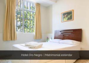 a bedroom with a large bed with a window at Hotel Oro Negro in Talara