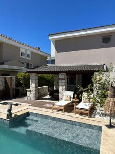a backyard with a swimming pool and a house at Detached house with pool in Alaçatı in Çeşme