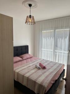 a bedroom with a bed with pink sheets and a window at Detached house with pool in Alaçatı in Çeşme +38 photos