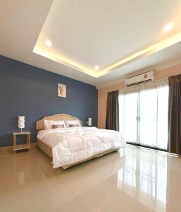ein Schlafzimmer mit einem weißen Bett und einer blauen Wand in der Unterkunft THAM Ranong in Ranong