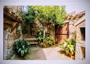 a stone building with a bench and a tree at Tu Casa de Pueblo in La Iglesuela +54 photos