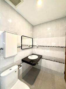 ein weißes Badezimmer mit Waschbecken und Toilette in der Unterkunft THAM Ranong in Ranong