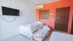 a room with two white tables and a flat screen tv at Suite em Guriri Norte com Piscina e Conforto in São Mateus +22 photos