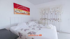 a white bedroom with a bed with white sheets at Suite em Guriri Norte com Piscina e Conforto in São Mateus