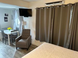 a bedroom with curtains and a chair and a table at Hotel Ponce de Leon in Miami