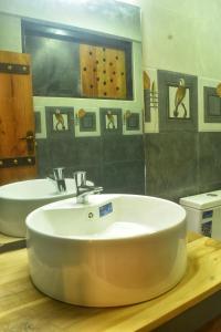 a bathroom with a white sink and a mirror at Patrius Bungalow by Daddy's Nest in Diyatalawa