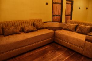 a brown couch with pillows sitting in a living room at Patrius Bungalow by Daddy's Nest in Diyatalawa